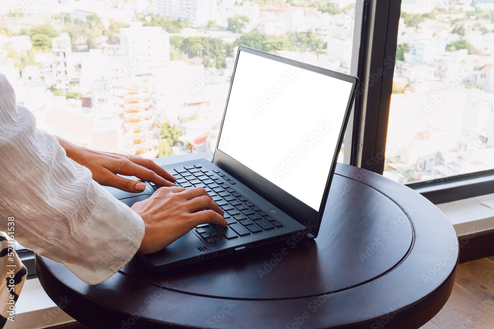 A woman working on a laptop, closeup of her hands and keyboard, the blank screen in the form of a clean template, businesswomen in the office on a light background.