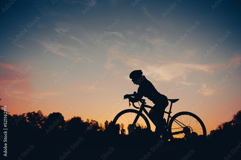 Obraz premium Sporty woman riding a bicycle in the nature while wearing a protective gear