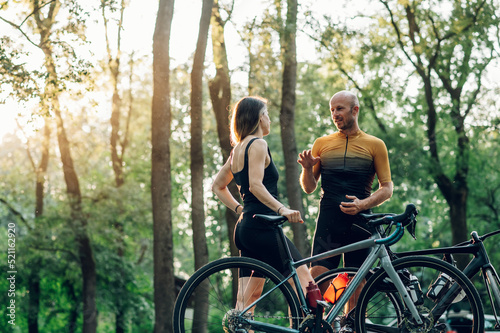 Happy couple riding road bicycles and taking a break during a sunset