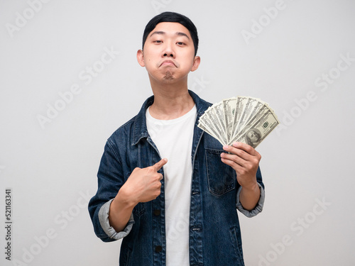 Young man jeabs shirt boast with money in hand point finger at himself isolated photo