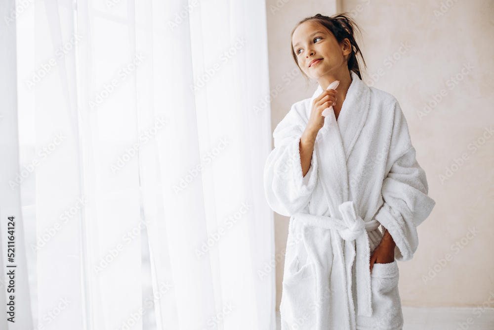 Girl doing self massage with rose quartz face roller Girl doing self massage with rose quartz face roller