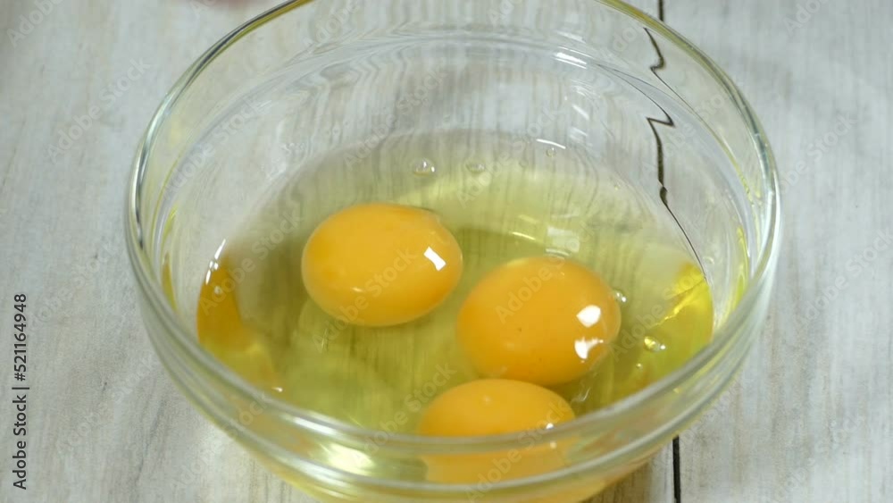 Preparing breakfast cooking yolk eggs. Opening raw eggs fro breakfast in close-up
