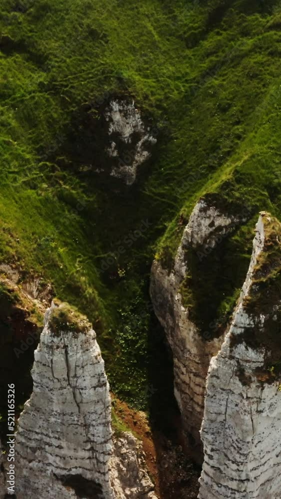 View from above on the bizarre peaks of sheer cliffs, overgrown with grass View from above on the bizarre peaks of sheer cliffs, overgrown with grass