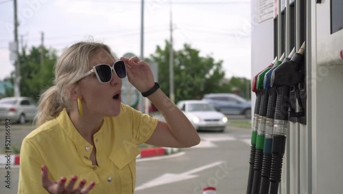 Angry displeased woman driving a gas station. A man is shocked by the price of gasoline. The concept of rapid growth in car fuel prices, crisis