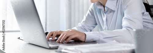 Businesswoman using laptop for financial and accounting work, Using computers to conduct financial transactions because the convenience, Freelancers work, Online communication, Internet, Wireless. © Puwasit Inyavileart