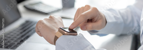 Businesswoman uses a smartwatch to make reminders or keep a small note of important messages on her wristwatch. Use of technology in work, Reminder Assistant,Watch time, Touch screen. photo