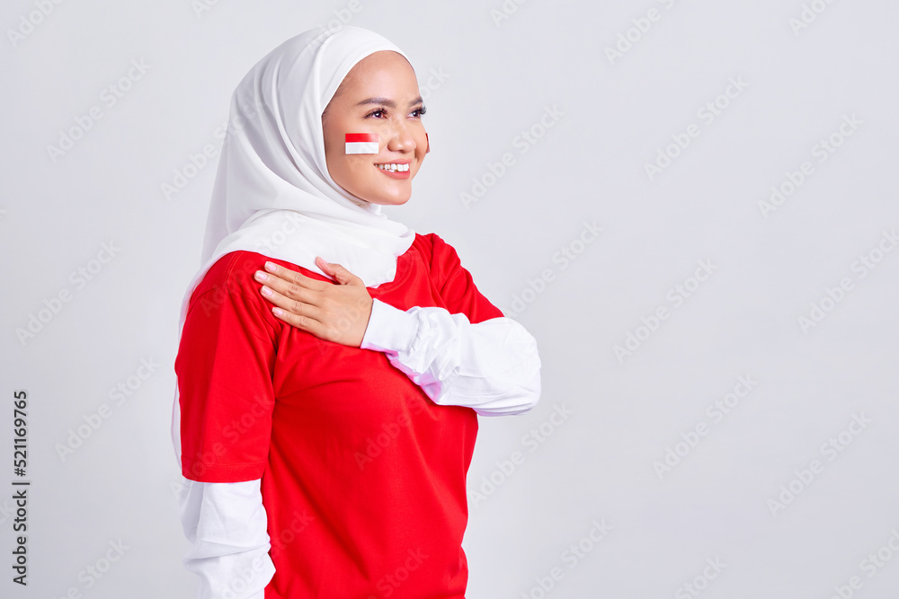 Happy young Asian muslim woman in red white t-shirt greeting to celebrating indonesian independence day on 17 august isolated on white background Happy young Asian muslim woman in red white t-shirt greeting to celebrating indonesian independence day on 17 august isolated on white background