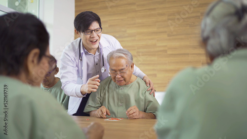 Portrait of happy group of old elderly Asian patient or pensioner people with a nurse and doctor playing games in nursing home. Senior lifestyle activity recreation. Retirement community. Health care