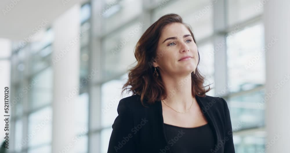 Confident, focused and powerful business woman walking down a corridor in a modern office building. Young female corporate professional going or leaving the workplace after a successful day