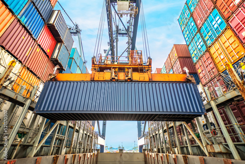 Industrial crane loading Containers in a Cargo freight ship. Container ship in import and export business logistic company. Container background for logistic and transportation concept.