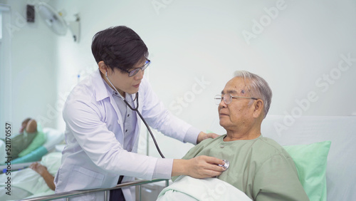 Portrait of Asian doctor check up body or heart by stethoscope of sick old senior elderly patient on bed in hospital in medical and healthcare treatment at nursing home. People lifestyle