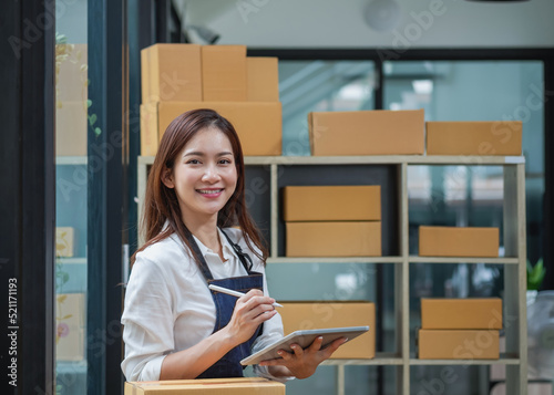 Young businesswoman using a tablet to check online product sales photo