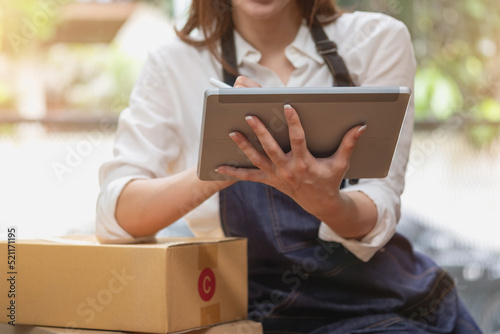 Young businesswoman using a tablet to check online product sales photo
