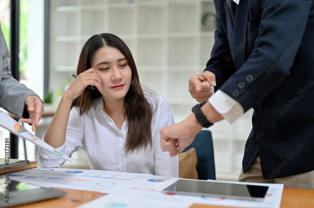 Female employee working and planning the marketing campaign with her team in the office. Female employee working and planning the marketing campaign with her team in the office.