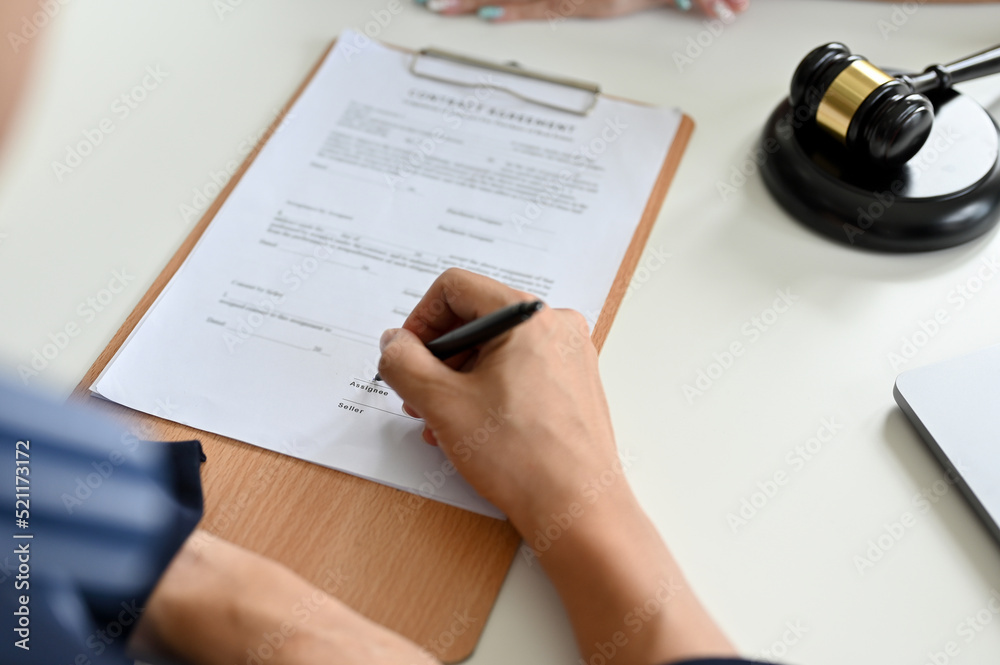 A male client sign his signature on a contract agreement paper. cropped image A male client sign his signature on a contract agreement paper. cropped image