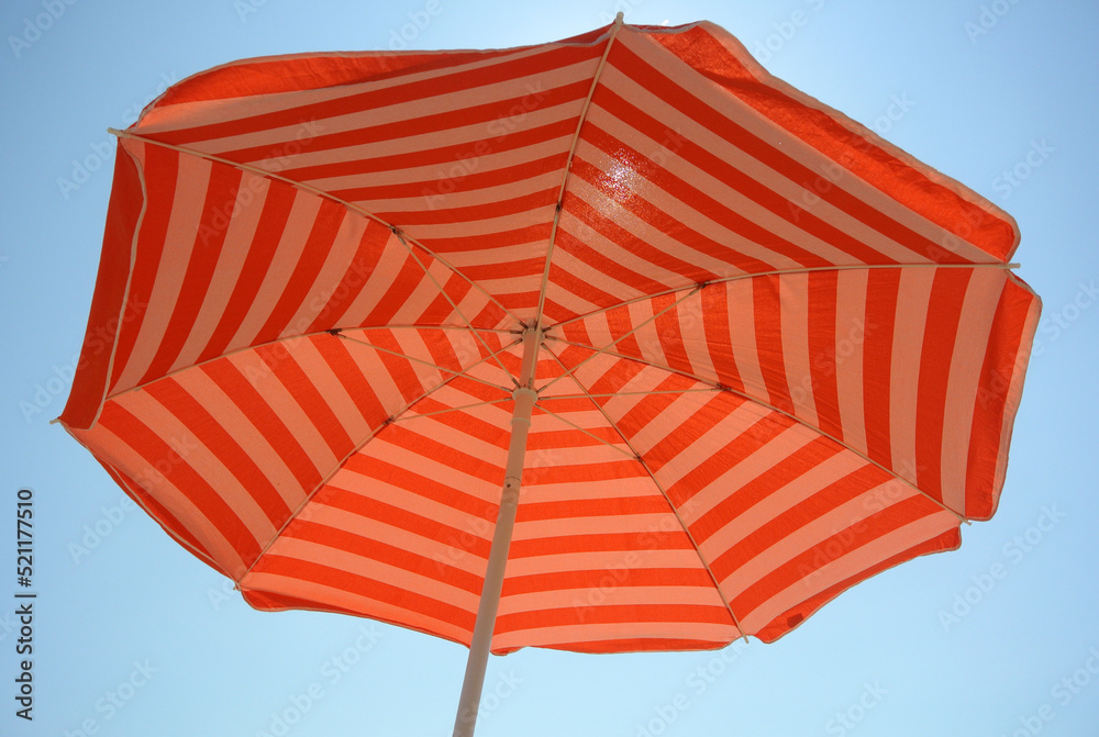 Orange gestreifter Vintage Sonnenschirm von unten mit Blick in den Himmel, Sonnenschutz, Urlaub im Süden