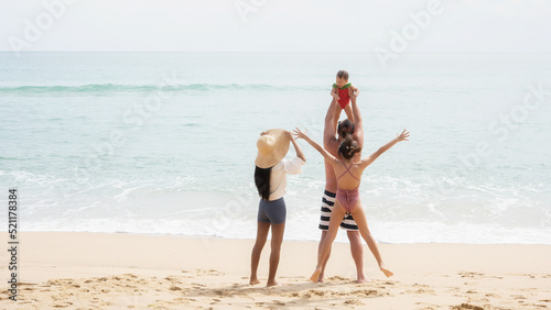 Happy family parents with children walking and having fun together on the beach in the summertime. Father, mother, and kids relax and enjoy the summer lifestyle travel holiday vacation