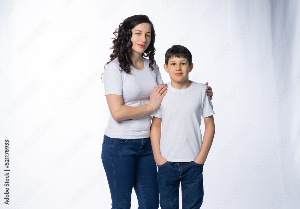 mother with son in jeans and white t-shirts on a white background. motherhood concept mother with son in jeans and white t-shirts on a white background. motherhood concept