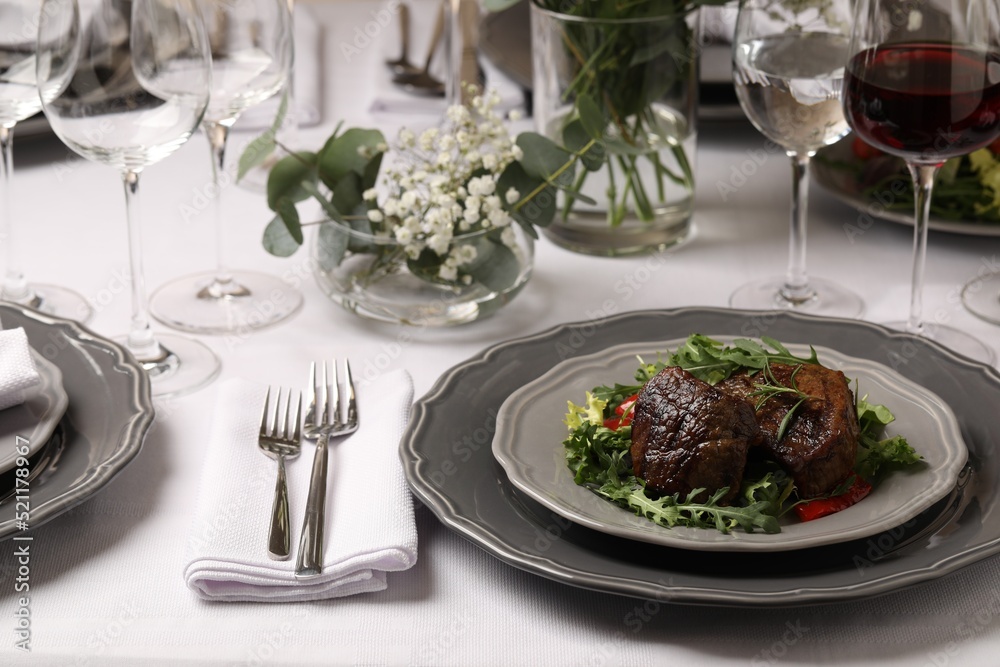 Delicious grilled meat with vegetables and wine served on table in restaurant Delicious grilled meat with vegetables and wine served on table in restaurant