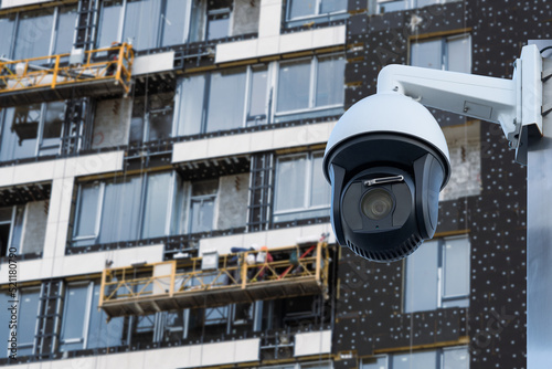 security CCTV camera or surveillance system with construction site on blurry background.