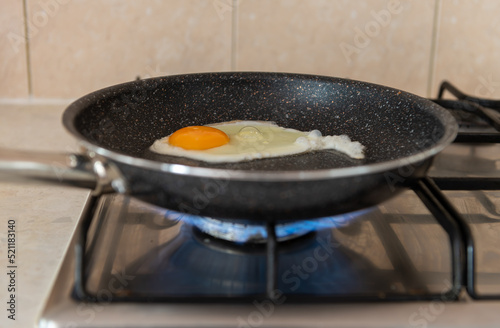 A frying pan on a cooker burning gas. Rising energy fuel cost concept. Energy crisis.