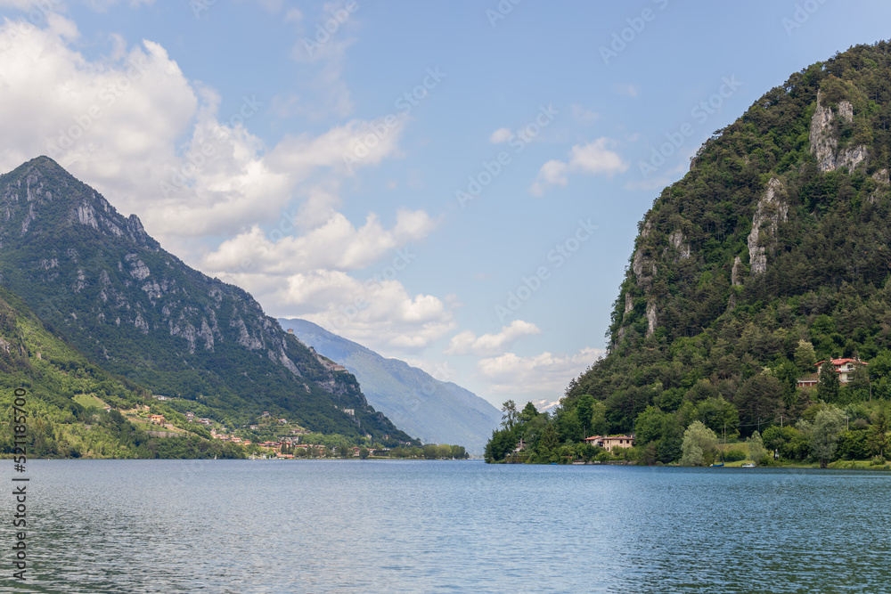 Italian prealpine lake Lago d'Idro surrounded by high cliffs overgrown with dense forest. Brescia, Lombardy, Italy
