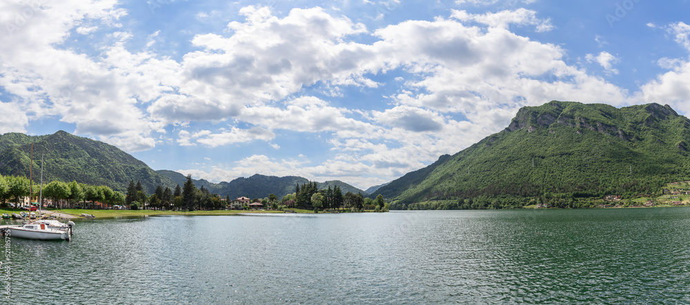 Panoramic view of the wooded Alps and the highest Lombard Lake Idro (Lago d'Idro), several boats on the pier near the shore. Brescia, Lombardy, Italy