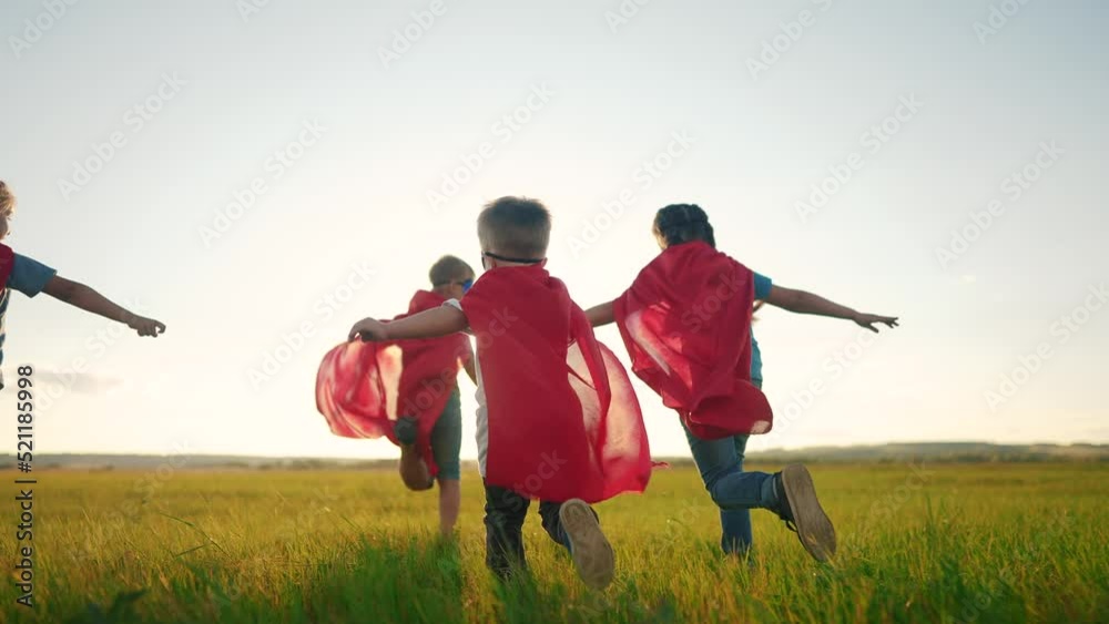 team of kids superheroes run. happy family kid concept. a group of children playing superheroes in capes and masks run through the grass at sunset. success business striving for the goal concept dream team of kids superheroes run. happy family kid concept. a group of children playing superheroes in capes and masks run through the grass at sunset. success business striving for the goal concept dream