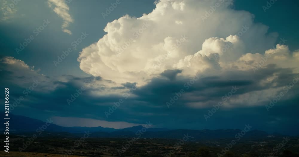 Timelapse of growing white cloud replaced by rainy dark sky. Epic nature landscape hyperlapse in 4k resolution. Countryside field and mountains on horizon
