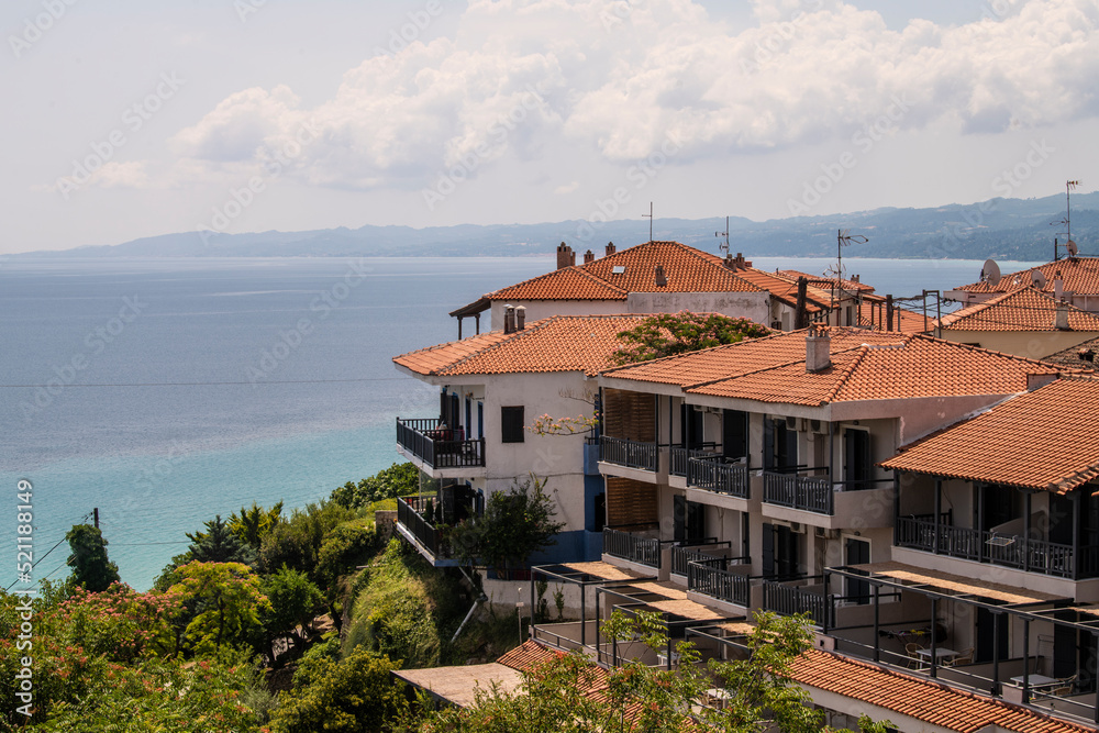 View of Sea and Rooftops of houses in village of Afitos or Athitos, situated on top of a hill with stone houses and cobbled streets. Kassandra,Chalkidiki,Greece 27.06.2022