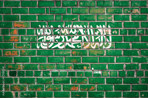 National flag of the Saudi Arabia on a grunge brick background.