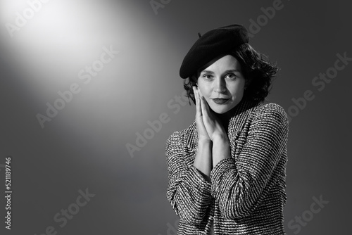 Portrait of beautiful woman in image of famous fashion designer posing in stylish classical clothes, jacket and hat. Black and white photography