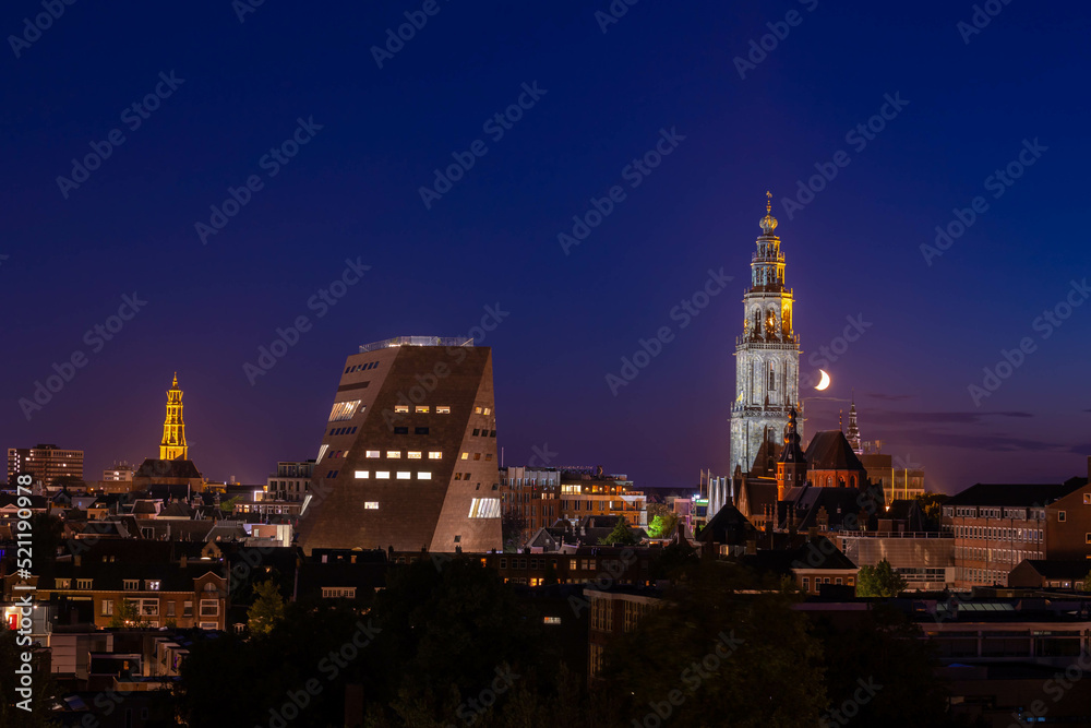Overview of cityscape with architecture features traditional houses and church at night, A city in the northern of Netherlands, The capital city and main municipality of Groningen province in Holland. - obrazy, fototapety, plakaty 