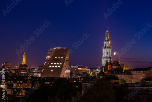Overview of cityscape with architecture features traditional houses and church at night, A city in the northern of Netherlands, The capital city and main municipality of Groningen province in Holland.