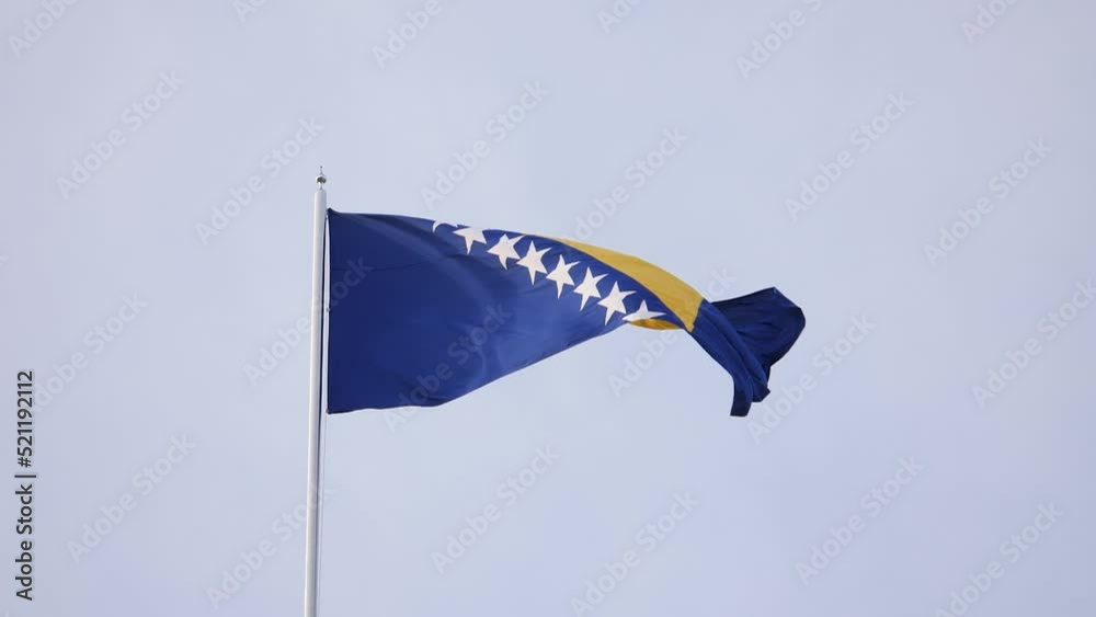 Slow motion footage of a Bosnian national flag swinging in the wind