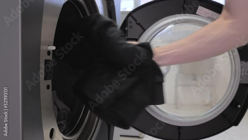 Man puts laundry in the washing machine