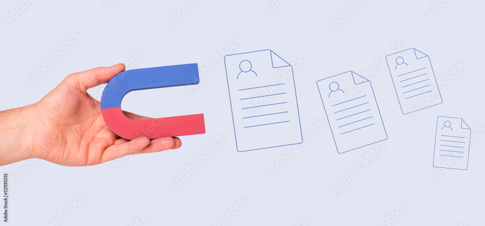 Human resources. Hand with magnet attracting CVs. HR manager searching for potential job seekers, talented workers. Headhunter. Demand for good specialists. High quality photo Human resources. Hand with magnet attracting CVs. HR manager searching for potential job seekers, talented workers. Headhunter. Demand for good specialists. High quality photo