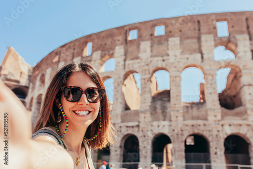 Photography Young cheerful caucasian woman taking selfie, in front of Colosseum, Rome, Italy