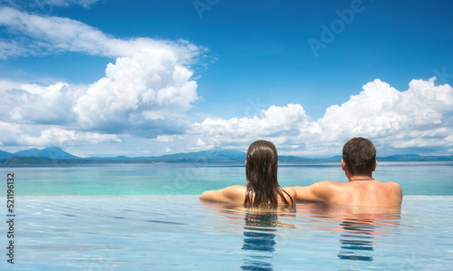 couple enjoying the view of mountain landscape from pool