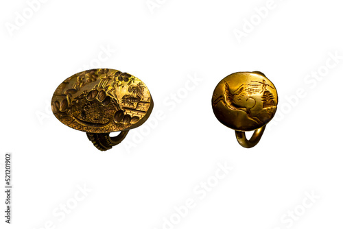 Set of 2 rings isolated on white background. The so-called ring of Minos and a golden ring depicting a griffin and a female figure with outstretched arms