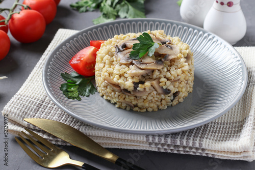 Bulgur garnish with champignons on a gray plate