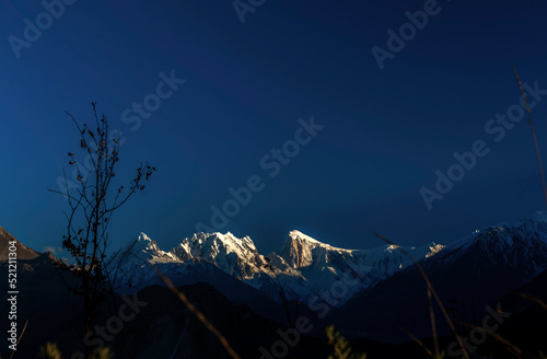 beautiful morning light on the snow capped mountains in blue sky, golden peak in nagar , gb Pakistan,  photo