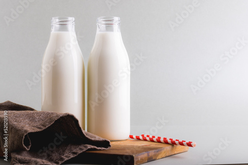 Milk in glass bottles against gray background with copy space