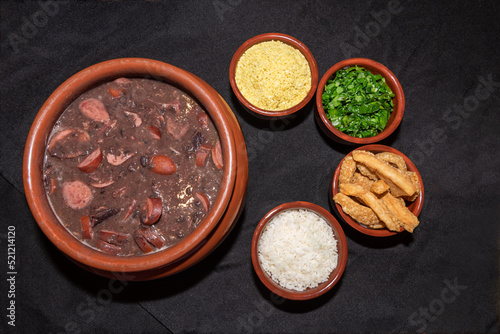 Delicious feijoada bowl with side dishes. Brazilian typical cuisine made with black beans and pork.