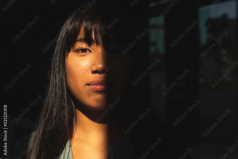 Asian female standing in shadow Asian female standing in shadow