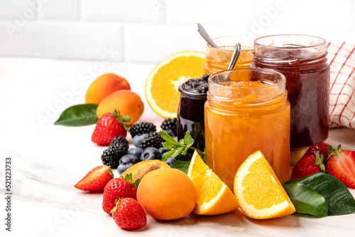 Jam in jar and strawberry apricot orange, blueberries blackberries