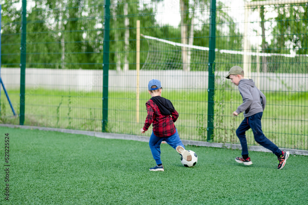 children play football in the yard, on the lawn