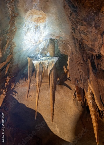 Vertical shot of a bright and shiny stalactite in La Cocaliere cave, France photo