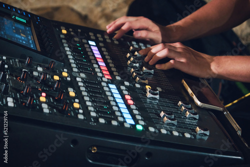 Fotografija Shot of a multi-track sound mixer for live events with a man's hands on the cons