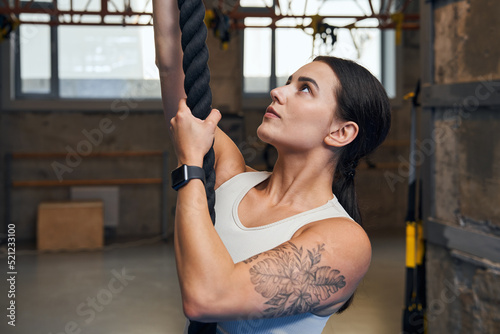 Female doing rope exercises at cross fit room at gym © Yakobchuk Olena